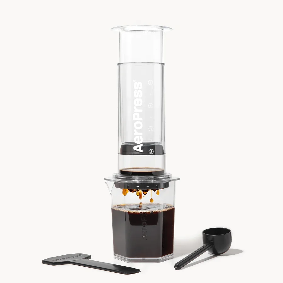 AeroPress Clear XL over its transparent serving carafe, with scoop and long stirrer